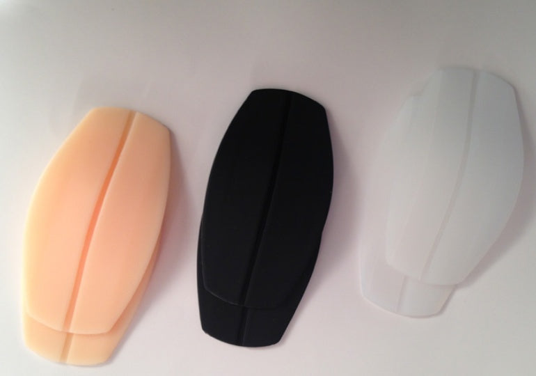 Silicone breast forms in peach, black, and white colors for enhancing natural shape.